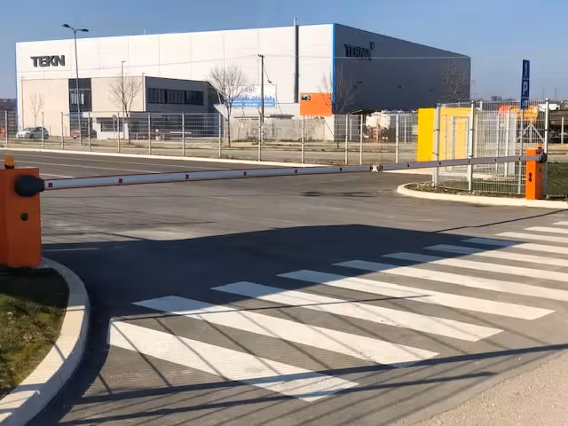 Dve narandžaste parking rampe na ulazu pored pešačkog prelaza.