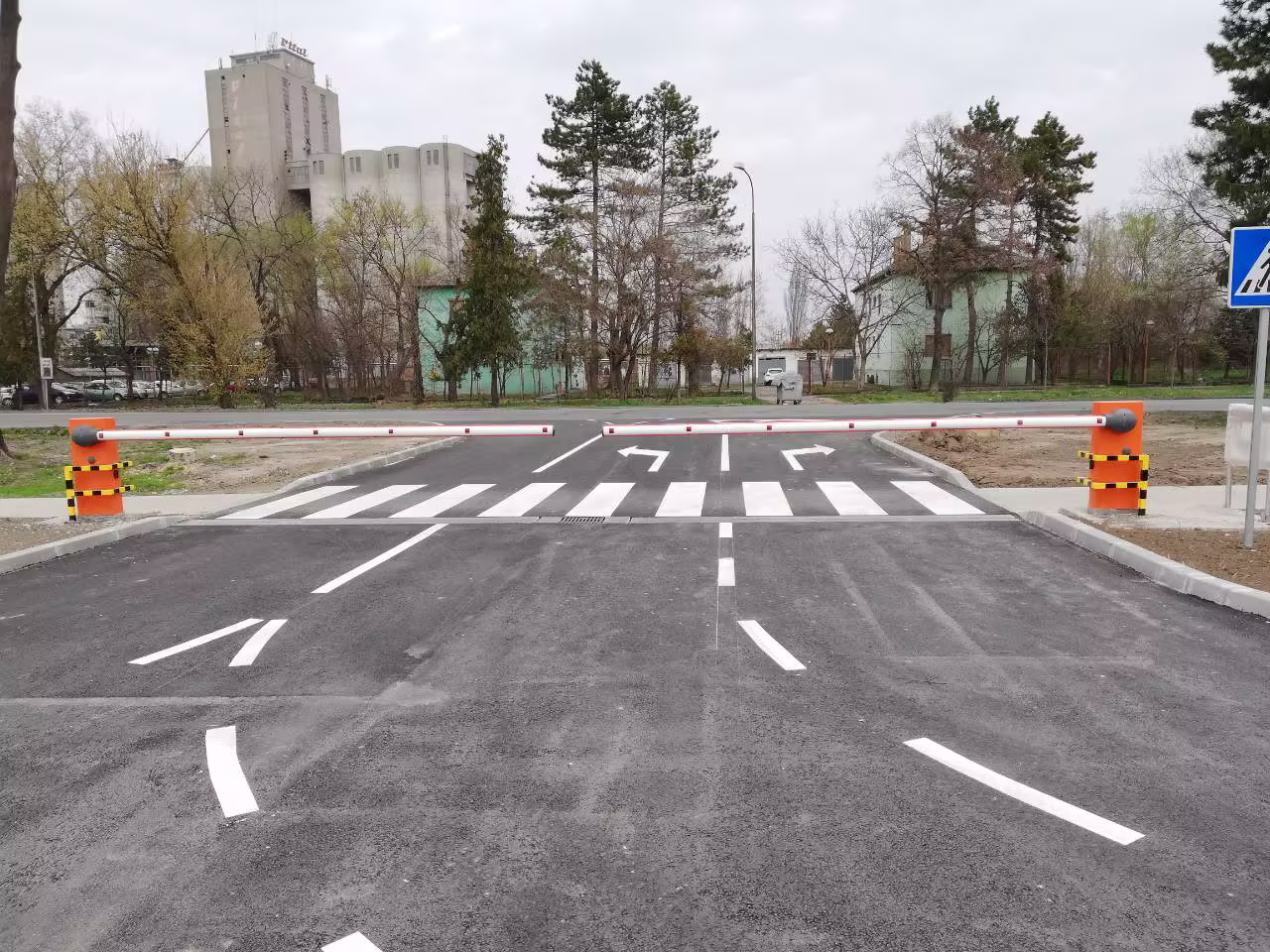 Dve narandžaste parking rampe sa spuštenim rukama preko označenih kolovoznih traka.